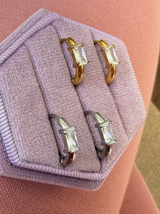 Gold and silver hoop earrings on a lavender velvet jewelry box