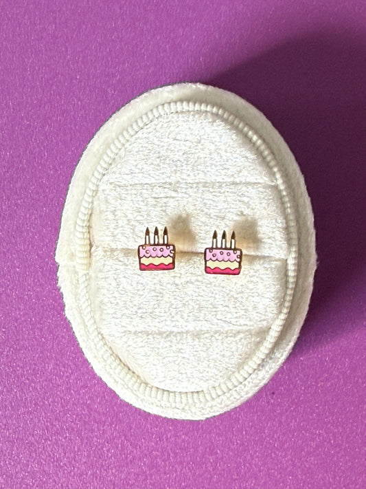 Birthday cake studs Shown over a white velvet oval jewelry box, showing enamel color details