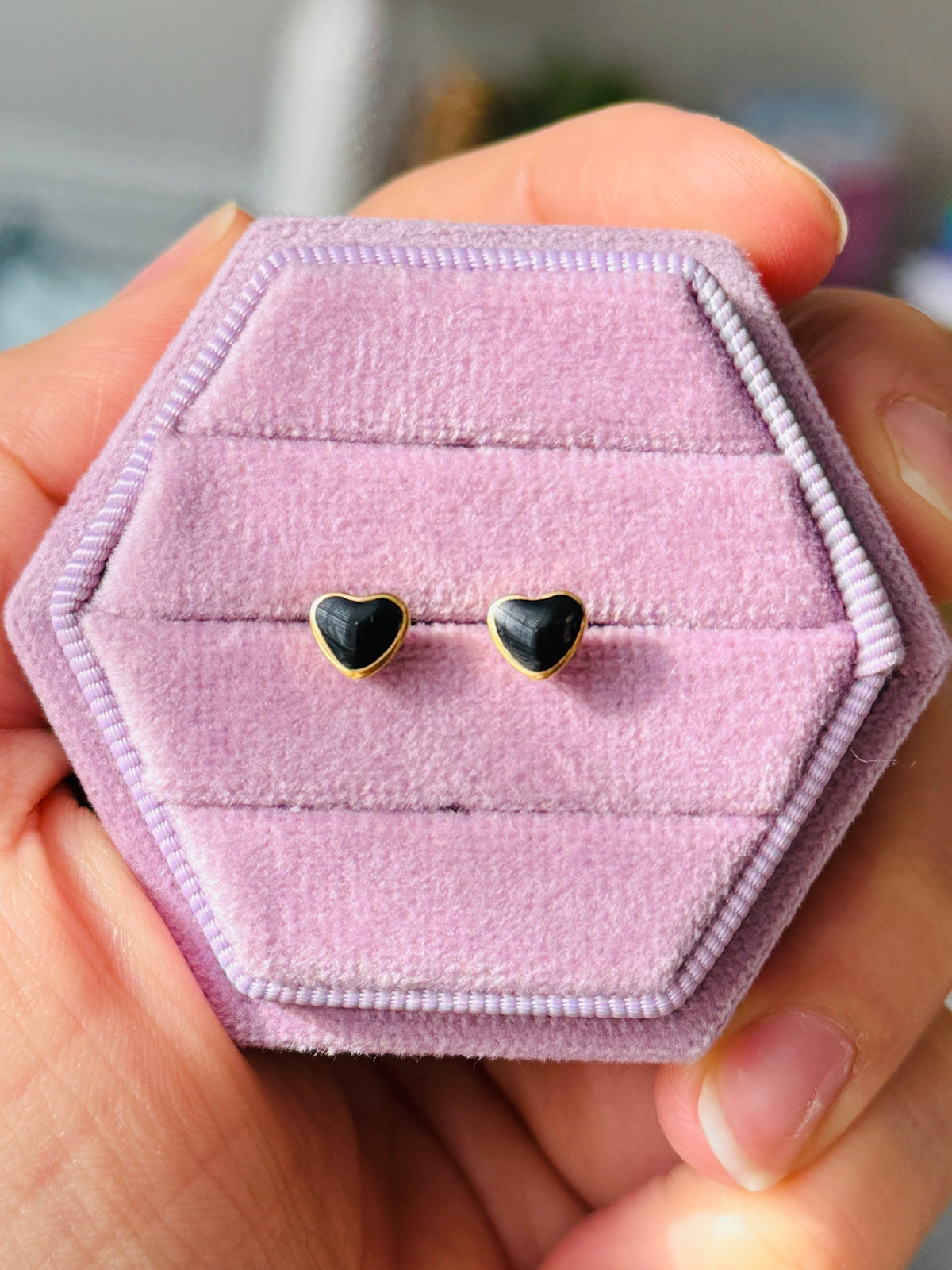 Black and Gold Heart Studs shown On light purple velvet jewelry box