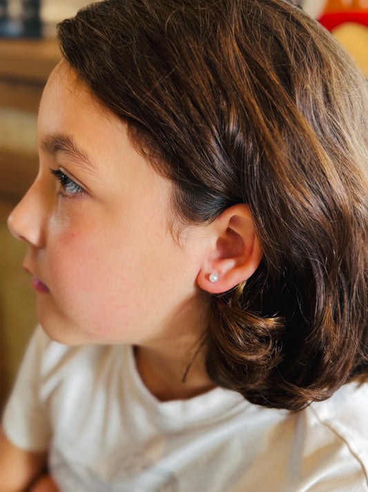 Faux pearls Screwback studs Being worn by a girl