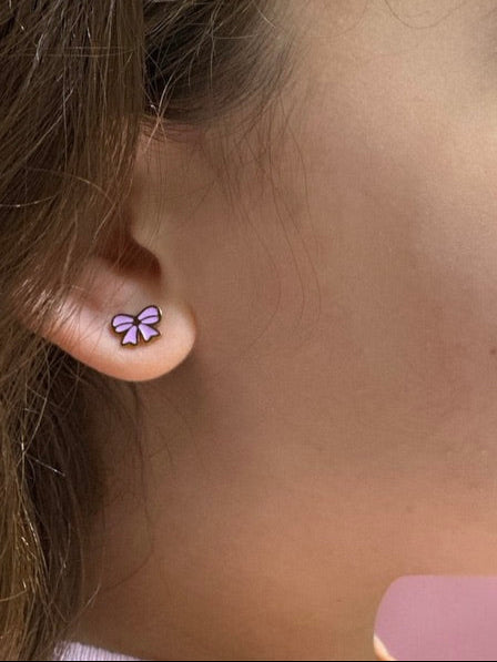 Pink and gold Screwback stud worn on an girls ear.