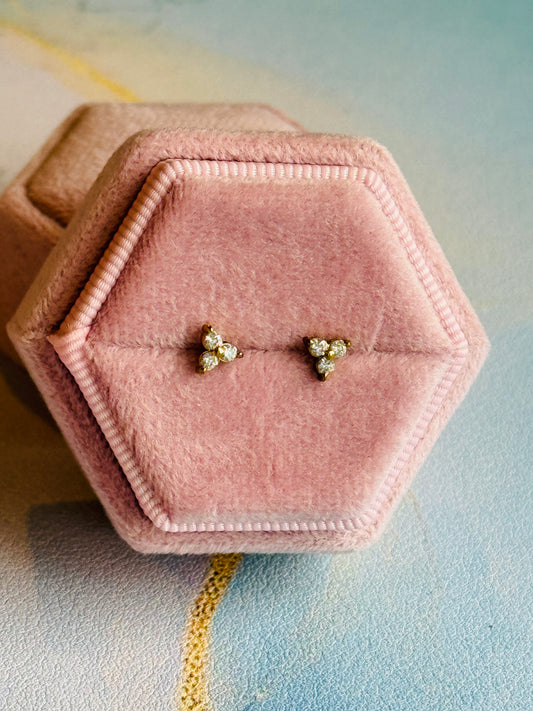 Pair of earrings in a pink hexagonal jewelry box on a soft background